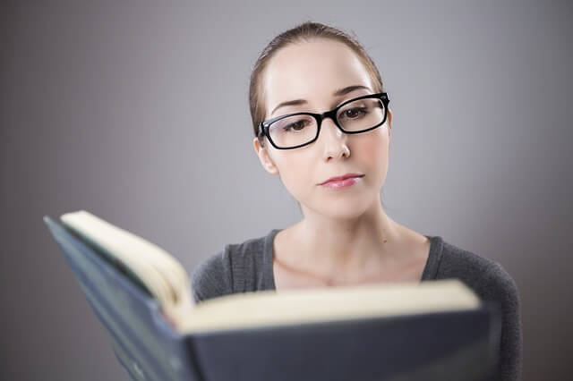 本を覗く眼鏡をかけた女性
