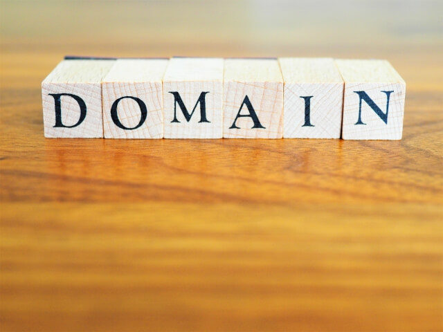 机の上にDOMAINの木製文字